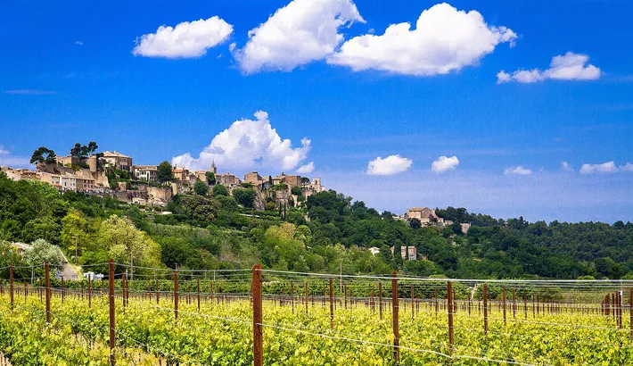 Le village perché de Ménerbes au-dessus des vignes du Luberon